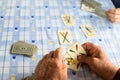 Elder hands playing cards on a blue table Royalty Free Stock Photo