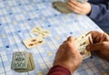 Elder hands playing cards on a blue table Royalty Free Stock Photo