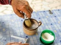 Elder hands using shaving brush with blade on blue table