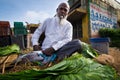 The elder Indian man sit and sale betel leaf at local morning ma