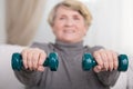 Elder lady training with dumbbells