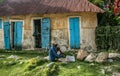 Elder man and child sit in front of house in rural Haiti.