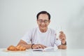 Elder man drinking milk and reading book while having breakfast Royalty Free Stock Photo