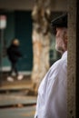 Elder man leaning on a wall facing a street in Perth, Australia