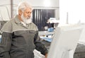 Elder man wearing grey uniform working on factory Royalty Free Stock Photo