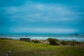 Elder man wearing a hat sits on a bench looking over stormy sea on an overcast day, contemplating the nostalgic sea-view Royalty Free Stock Photo