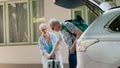 Elder people loading vehicle with baggage and trolleys Royalty Free Stock Photo