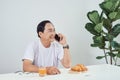 Elder person talking on cellphone while having breakfast
