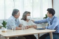 Elder senior old asian couple meeting specialist professional caucasian doctor visit at home consultant two retirement patient