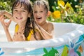 The elder sister and younger brother are indulging in an inflatable pool in the garden,