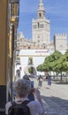 Elder tourist woman taking pictures to The Giralda, Seville, Spain Royalty Free Stock Photo