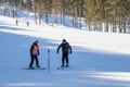 A elder trainer teaches a man skiing