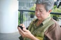 elder woman holding mobile phone. elderly senior female texting Royalty Free Stock Photo