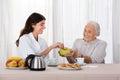 Elder Woman Offering Snack To Nurse