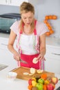 Elder woman peeling apples in kitchen Royalty Free Stock Photo