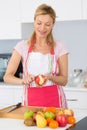 Elder woman peeling apples in kitchen Royalty Free Stock Photo