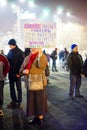 Elder woman with protest message, Bucharest, Romania