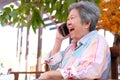 Elder woman talk on mobile phone in garden. elderly female speak Royalty Free Stock Photo