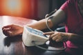 Elder woman upper arm bicep in cuff. Older retired lady measuring manually blood pressure, using digital tonometer machine at home Royalty Free Stock Photo