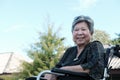 elder woman on wheelchair smiling & resting in garden. happy elderly female relaxing outdoors. mature lifestyle concept Royalty Free Stock Photo