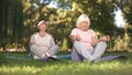 Elder women sitting in lotus position and meditating doing yoga in park, energy Royalty Free Stock Photo