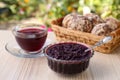 Elderberry Sambucus jam, glass cup of tea and tasty cookies on wooden table outdoors Royalty Free Stock Photo