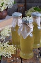 Elderflower cordial syrup and blossom flower in wooden background. Edible elderberry flowers add flavour and aroma to drink and de Royalty Free Stock Photo