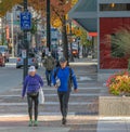 An elderly active couple wearing sports clothes is walking on the street in Vancouver city BC active aging