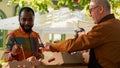 Elderly adult selling seasonal homegrown produce at farmes market