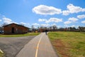 An elderly African American man with a cane walking along a smooth footpath with a yellow line in the park Royalty Free Stock Photo