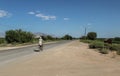 Elderly armenian Man with white bear in a vintage bike sending greetings with the hand