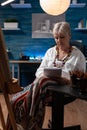 Elderly artist doing sketch on notebook for practice before drawing on easel