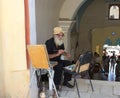 An elderly artist at the entrance to the monastery