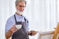 mature elderly artist man drink tea during work in studio