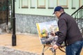 Elderly artist paints a picture of oil in Andrew's Descent