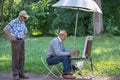 Elderly artist and spectator in the summer park