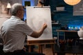 Elderly artist working on vase drawing with pencil on canvas