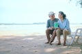 Elderly Asian couple holding laptops green screen on the beach Royalty Free Stock Photo