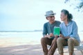 Elderly Asian couple holding laptops green screen on the beach Royalty Free Stock Photo