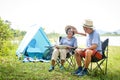 Elderly Asian couples camping in the jungle enjoying a retirement vacation.