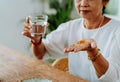 Elderly Asian man taking pill