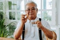 Elderly Asian man taking pill