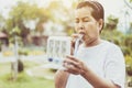 Elderly asian mother using incentive spirometer or three balls for stimulate lung at nature Royalty Free Stock Photo