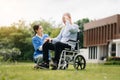 Elderly asian senior man on wheelchair with Asian careful caregiver. Nursing home hospital garden concept are walking in the Royalty Free Stock Photo