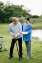 Elderly asian senior man on wheelchair with Asian careful caregiver. Nursing home hospital garden concept Royalty Free Stock Photo