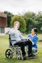 Elderly asian senior man on wheelchair with Asian careful caregiver. Nursing home hospital garden concept are walking in the Royalty Free Stock Photo