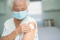 Elderly Asian senior woman wearing face mask getting covid-19 or coronavirus vaccine by doctor make injection Royalty Free Stock Photo