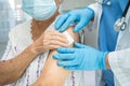 Elderly Asian senior woman wearing face mask getting covid-19 or coronavirus vaccine by doctor make injection Royalty Free Stock Photo