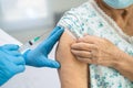 Elderly Asian senior woman wearing face mask getting covid 19 or coronavirus vaccine by doctor make injection Royalty Free Stock Photo