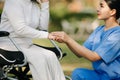 Elderly asian senior woman on wheelchair with Asian careful caregiver. Nursing home hospital garden concept Royalty Free Stock Photo